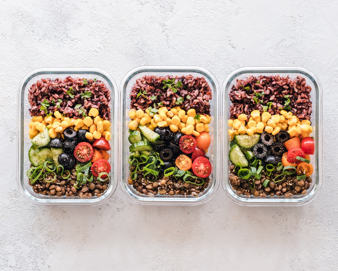 A family preparing healthy meals together in a kitchen, showcasing fresh ingredients and meal prep containers.